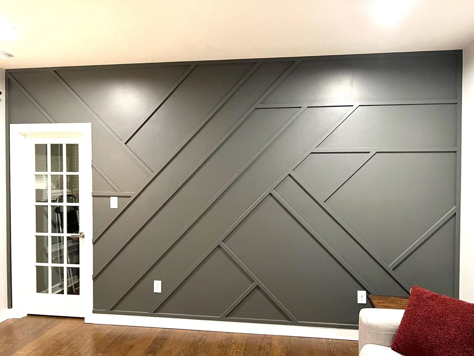Full-width graphite geometric accent wall in a finished living room