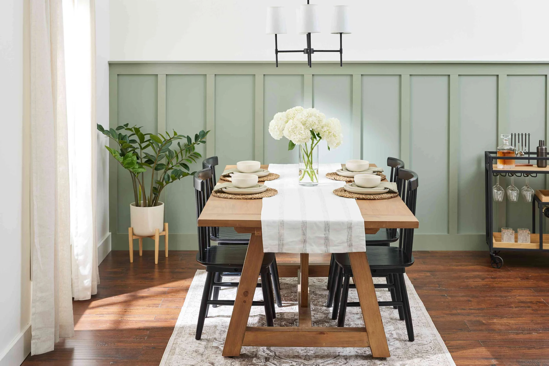 Sage green wainscoting in a bright dining room